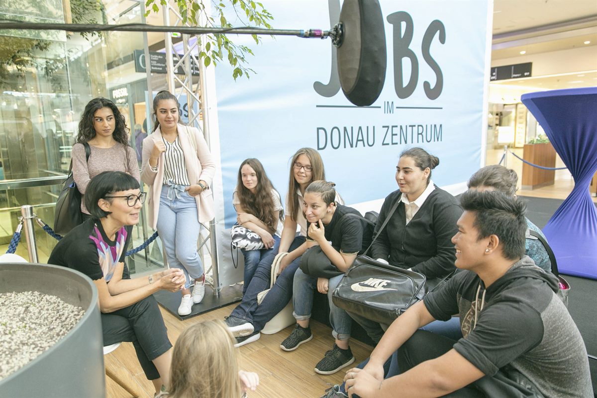 Interessierte Jugendliche mit Unternehmerin und Mode-Journaslistin Irmie Schüch-Schamburek bei der Jobmesse im Donau Zentrum 