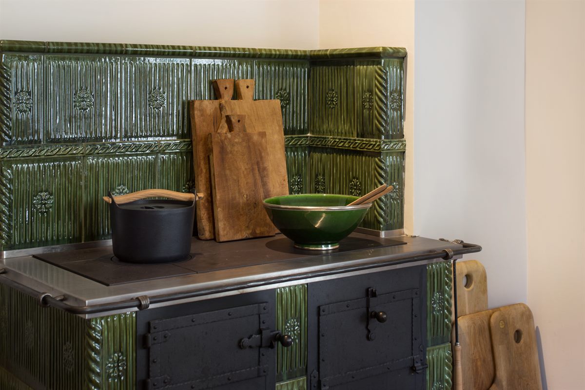 Haus Alte Blaa: In der offenen High-end Wohnküche steht ein traditioneller Kachelofen 