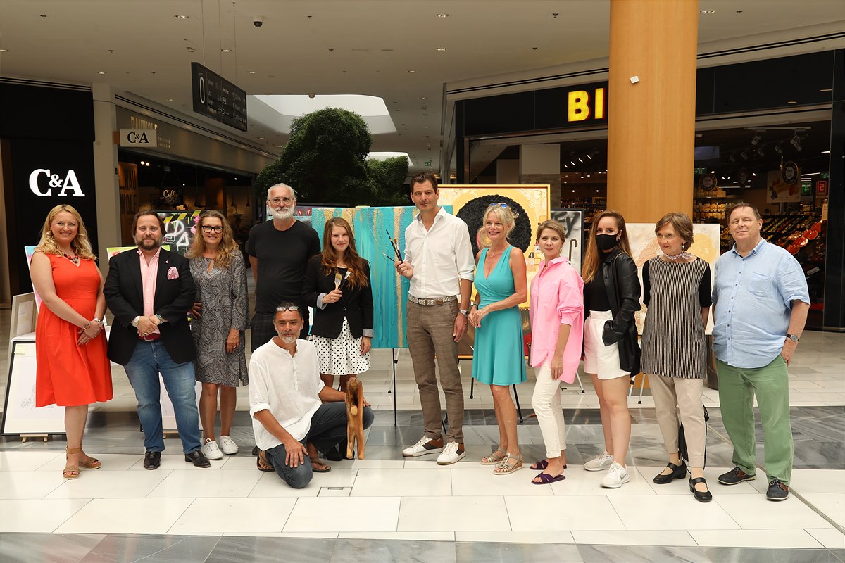 Gruppenbild mit allen Künstler:innen, Hannes Koza (Bgm. Vösendorf), Melanie Fraiss (Stv. Center Managerin) und der Kuratorin Isabel Simonel