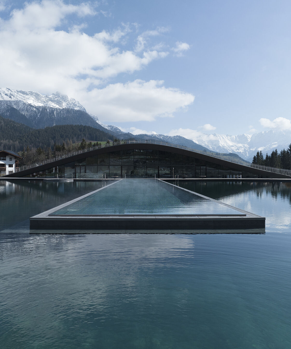 Das organisch designte Spa, der 5.500 m2 große Natur-Badesee und der 50 Meter lange Infinity-Pool fügen sich harmonisch in die Landschaft ein.