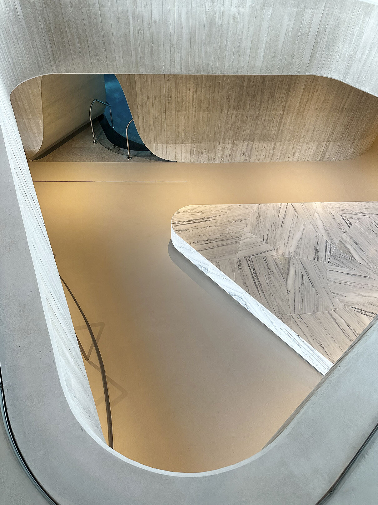 Offene Architektur und organische Formen als zentrales Thema im ganzen Spa: Salzburger Alpenmarmor im Blick von oben.