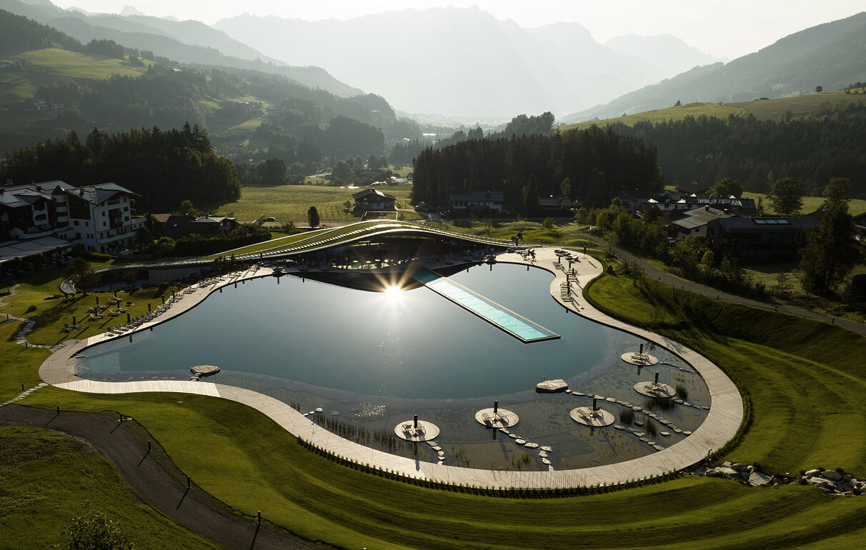 Das organisch designte Spa ATMOSPHERE by Krallerhof, der 5.500 m2 große Natur-Badesee und der 50 Meter lange Infinity-Pool fügen sich harmonisch in die Landschaft ein.