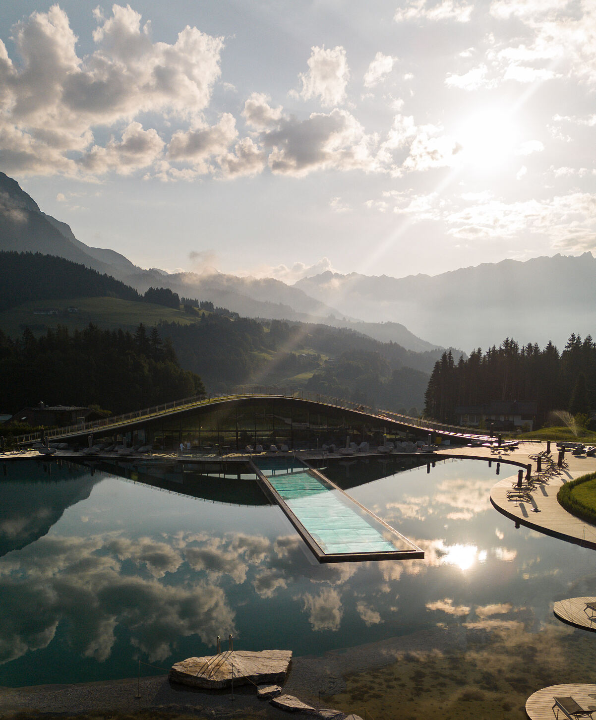Das organisch designte Spa ATMOSPHERE by Krallerhof, der Natur-Badesee und der 50 Meter lange Infinity-Pool fügen sich harmonisch in die Landschaft ein.