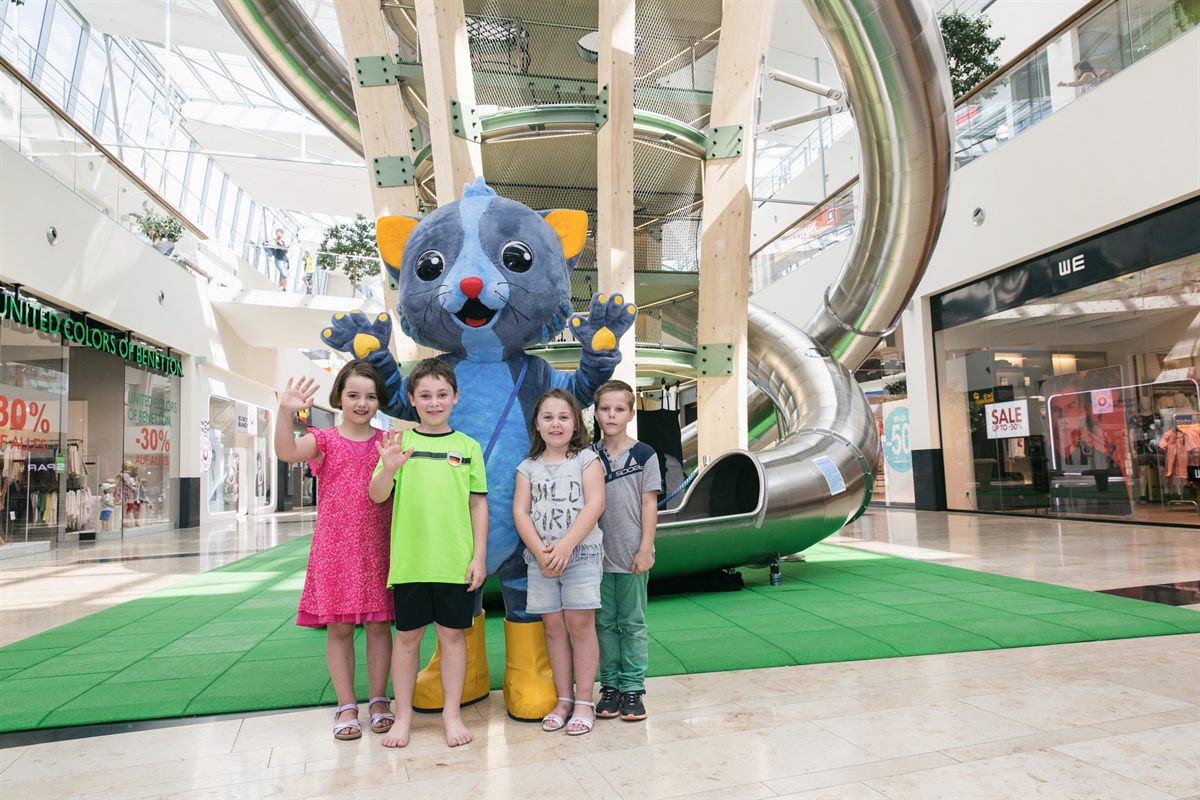 Das neue Donau Zentrum-Maskottchen KaDZi mit Kindern vorm Kletterbaum